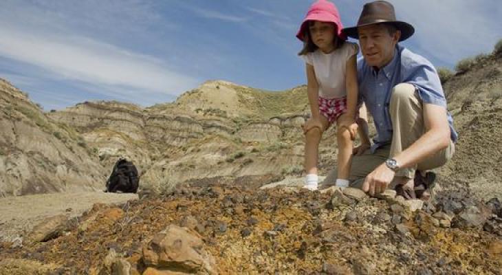 An adult and child look at rocks in the badlands