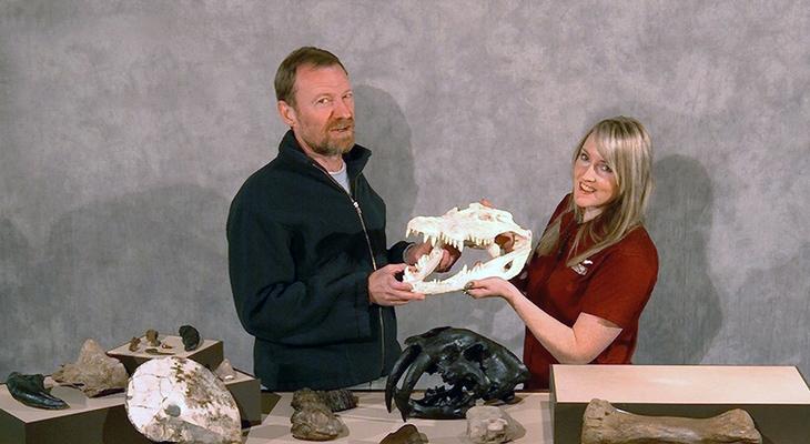 Two educators hold a crocodile skull.